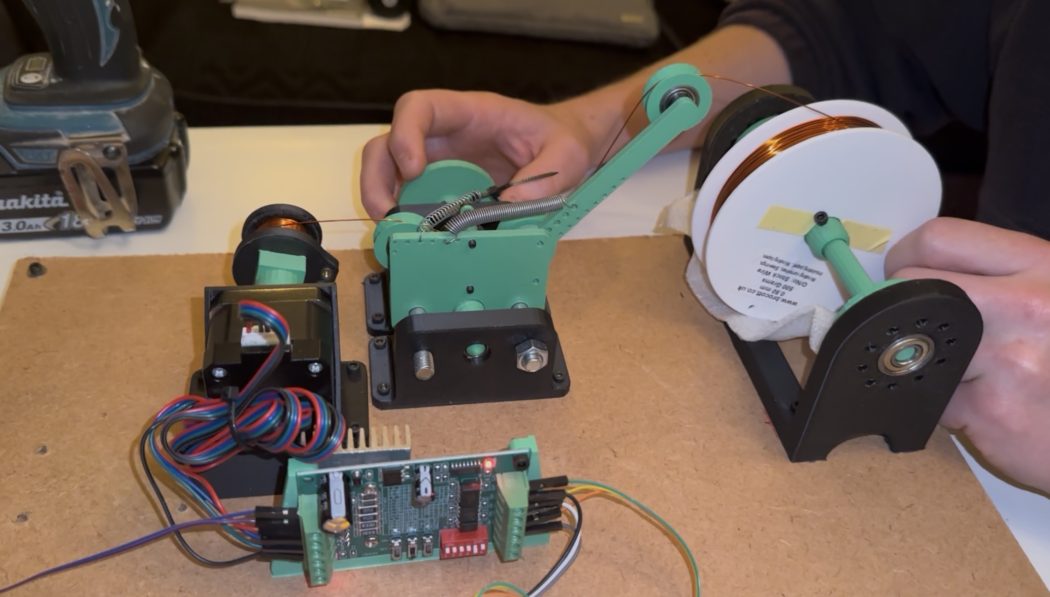 Custom electromagnet winding rig with NEMA stepper motor, tensioning arm, and lead screw